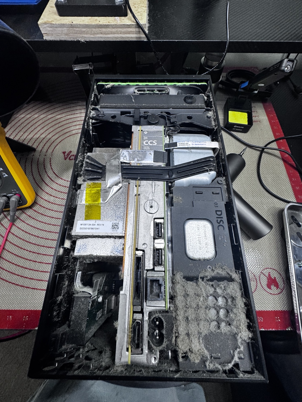 Opened game console showing heavy internal dust buildup